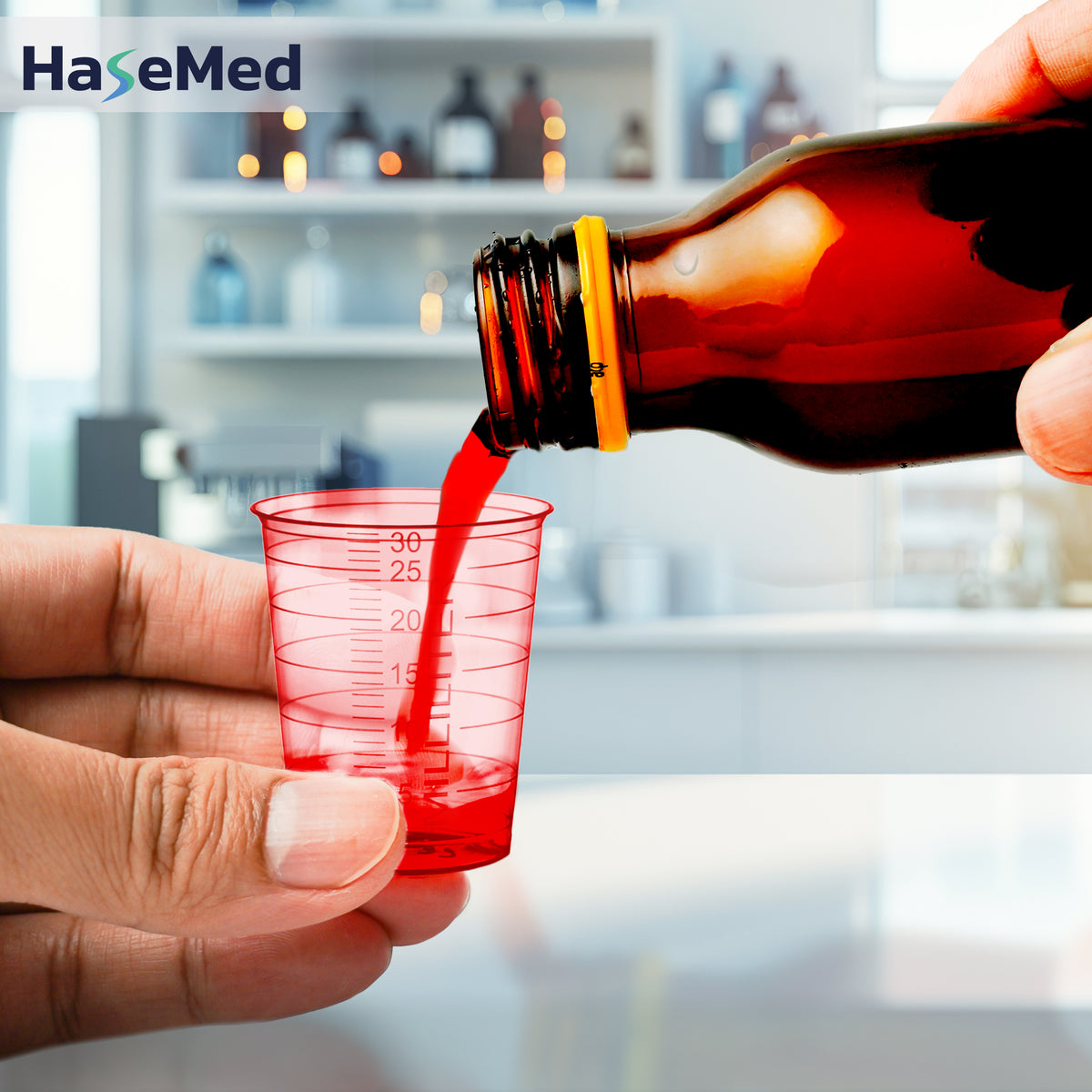Bicchierino per medicinali HaseMed da 30 ml rosso in uso; venduto in confezioni da 80 bicchierini di un solo colore, senza coperchi. Liquido e flacone non inclusi.