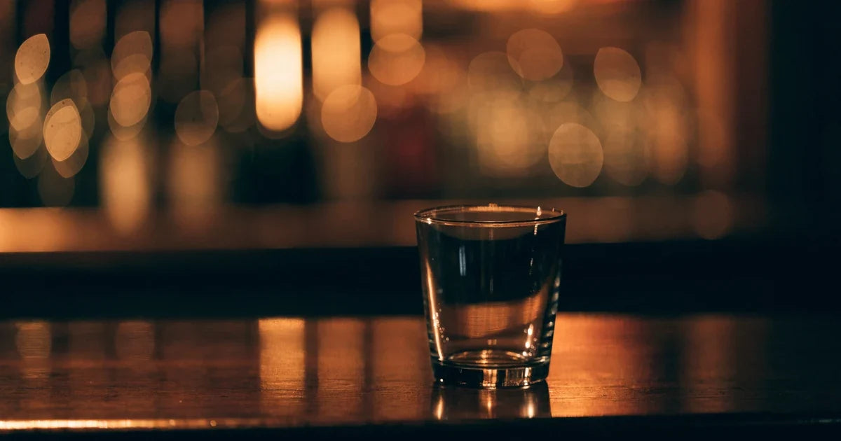 Pozostawiony bez opieki drink na barowej ladzie w przygaszonym świetle